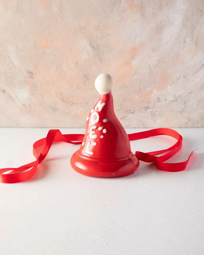A festive Christmas tree resembling a hat, made from 500g of pure Belgian milk and coloured chocolate, ideal for holiday gifting.