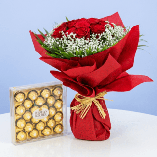 A bouquet of 10 red roses with gypsophila and greenery, wrapped in red paper and paired with a box of Ferrero Rocher chocolates.