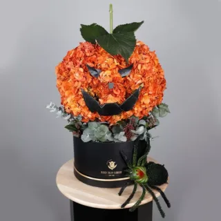 Halloween Pumpkin bouquet decorated with spray orange hydrangeas and lush greens, featuring a scary spider at the bottom.