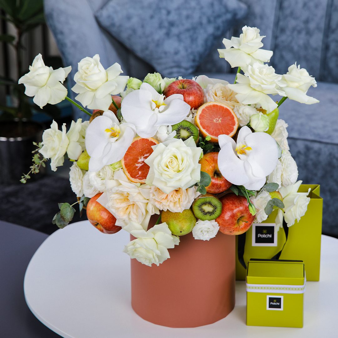 Peaceful Fruit Arrangement composed of mix fruits and flowers in a box with Patchi by Black Tulip Flowers.