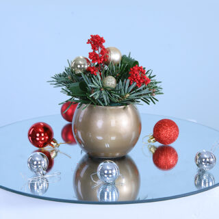 A silver-colored bowl filled with lush Christmas florals, featuring pines and ferns, perfect for holiday decor.