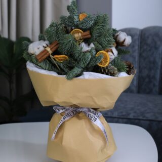 Christmas bouquet featuring cones, dried oranges, and delicate cotton flowers for a touch of rustic elegance.