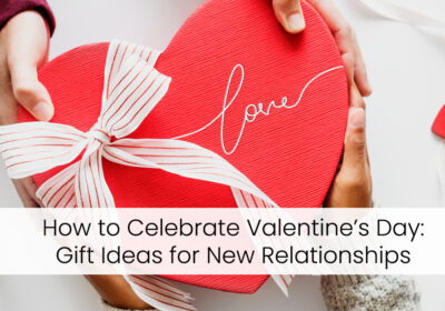 How to Celebrate Valentine’s Day: Gift Ideas for New Relationships 9 Two hands, one light and one dark, holding a heart-shaped gift box with a red ribbon and the word "Love" written on it. The text "How to Celebrate Valentine's Day: Gift Ideas for New Relationships" is displayed below the image.