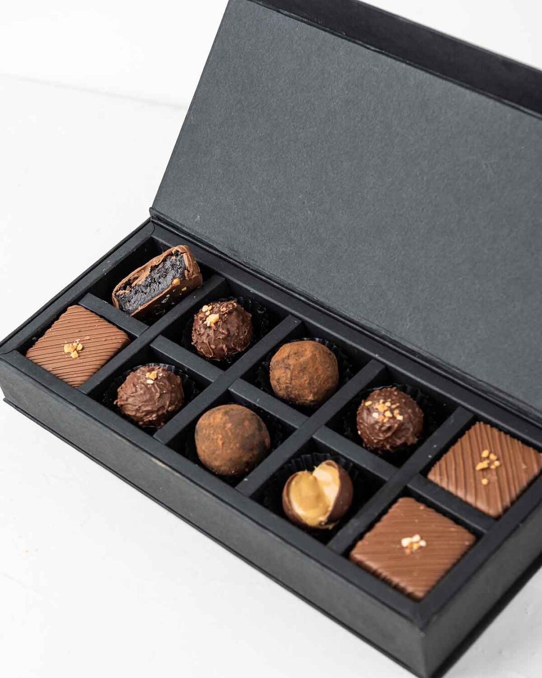 10pcs truffles and brownie cake bites in various flavours arranged in an elegant black box