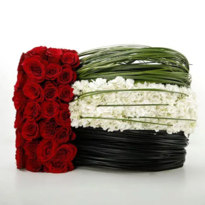 Celebrate UAE Flag Day with Creative Activities and Decorations 3 A floral arrangement designed in the colors of the UAE flag: red, green, white, and black. The arrangement features red roses, white hydrangeas, and green grass-like elements, arranged in a circular shape.