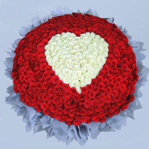 A large, luxurious bouquet of red roses with heart made of white roses at the centre.