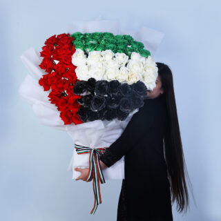 A bouquet of vibrant UAE flag-colored roses, wrapped in white paper and tied with a matching flag-colored ribbon.