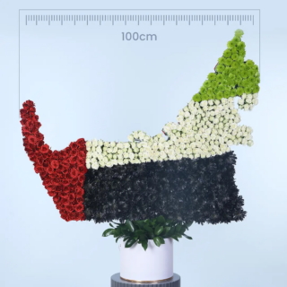 A floral arrangement in the shape of the UAE map, featuring white, red, black, and green flowers.