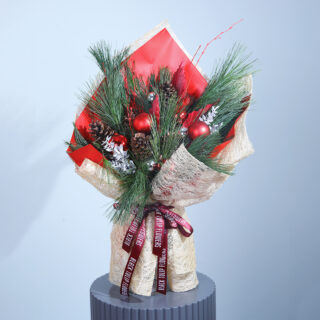 A festive Christmas bouquet with red and green blooms, pinecones, and ornaments.