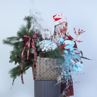 A festive Christmas basket arrangement featuring hydrangea, ilex berries, anthurium, erengium, and pine leaves.