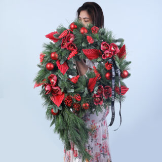 A festive Green and Red Christmas Wreath adorned with vibrant red blooms, lush greenery, and holiday accents.