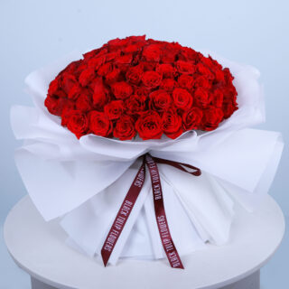 Flower Delivery Abu Dhabi 66 Bouquet of 101 red roses tied elegantly arranged in white wrap and tied with maroon ribbon.