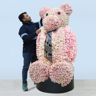 Giant teddy bear arrangement made of soft baby pink roses, finished with a black ribbon