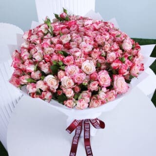 BTF Home 67 A bouquet of fresh 50 pink baby roses wrapped elegantly in a white paper and tied with a black knot.
