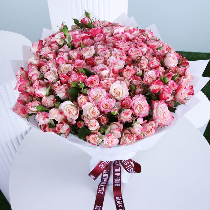 grand-baby-rose-bouquet A bouquet of fresh 50 pink baby roses wrapped elegantly in a white paper and tied with a black knot.