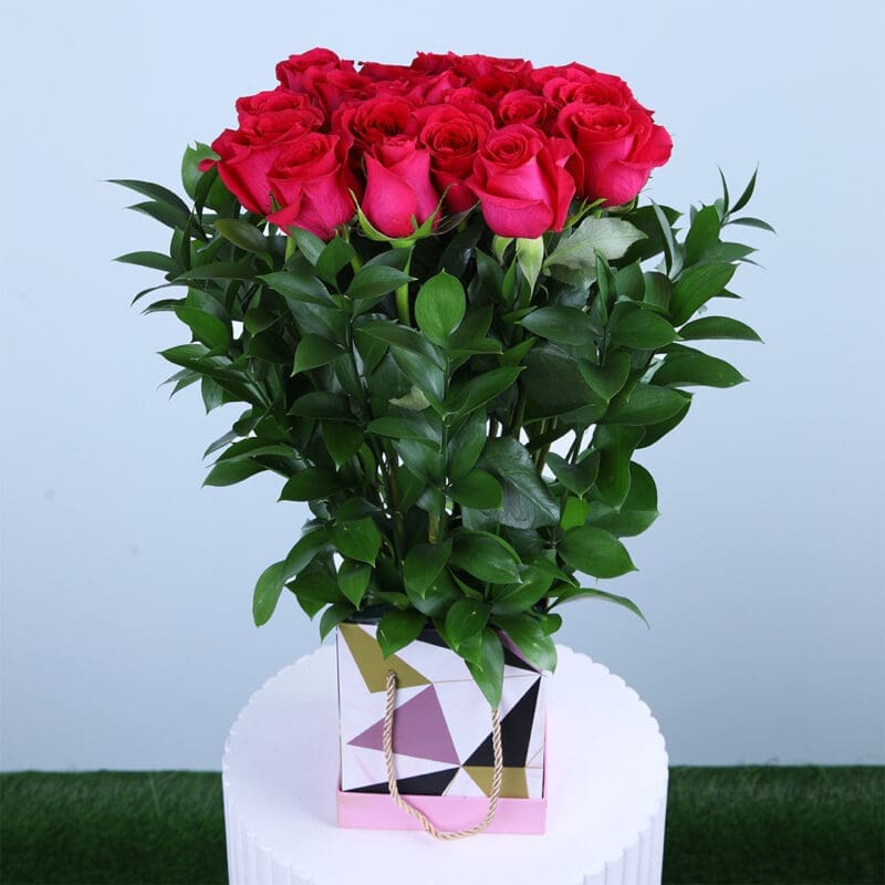 Elegant Dark Pink Roses A bunch of dark pink roses and fresh green leaves in a square geometric patterned gift box.