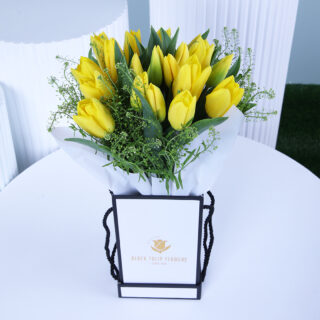 Yellow tulips floral box in a white wrap, elegantly presented with a gift box.