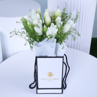 White tulips bouquet in a white wrap, elegantly presented with a gift box.