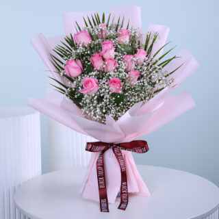 A stunning bouquet of fresh pink roses, elegantly wrapped with baby’s breath and greenery, perfect for any special occasion.