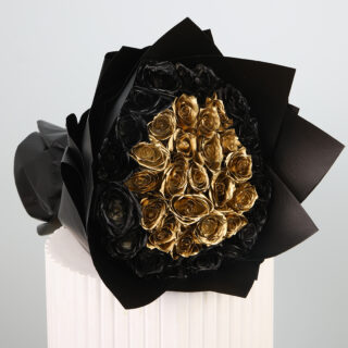 A luxurious bouquet of black and gold roses wrapped in black.