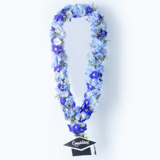 A graduation garland made of blue and white flowers with greenery with a small black graduation cap with the word "Congratulations!".