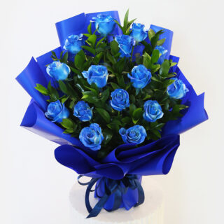 A graduation garland made of blue and white flowers with greenery with a small black graduation cap with the word "Congratulations!"