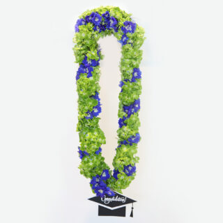 A graduation garland made of light green and blue flowers with a small black graduation cap with the word "Congratulations!".