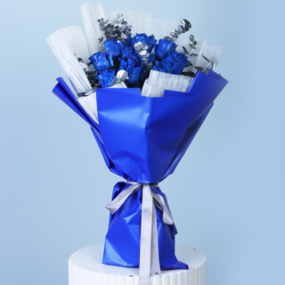 A stylish bouquet featuring sapphire blue painted roses and silver painted eucalyptus leaves, wrapped in blue and tied with a silver ribbon.