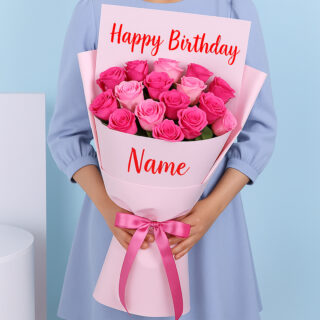 Flower Delivery Abu Dhabi 33 A bouquet of pink roses, wrapped in soft pink, featuring “Happy Birthday” at the top and a personalized name at the bottom. A pink ribbon is tied in a bow around the bouquet.