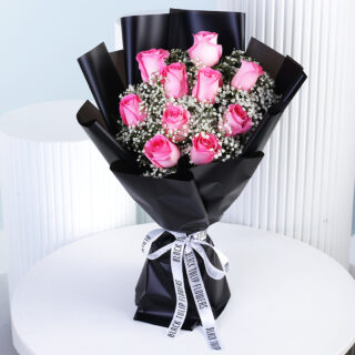A charming arrangement of pink roses and white gypsophila, elegantly wrapped in black and finished with a crisp white ribbon.