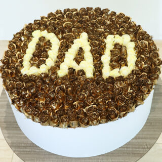 A large floral arrangement made of gold-coloured roses, with the word "DAD" spelled out in cream-colored roses in the center in a white round box.