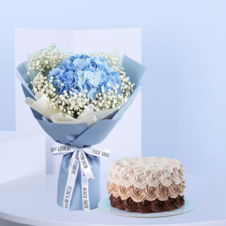 A blue hydrangea and baby's breath bouquet wrapped in blue and white with a white ribbon and a round ombre rosette cake frosting from dark brown to light cream.