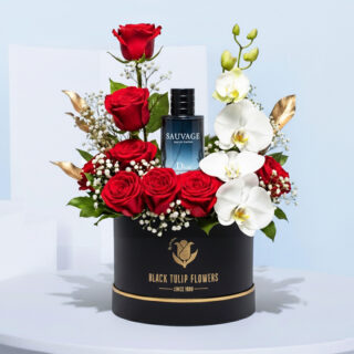 Flower box with red roses, white phalaenopsis orchids, baby’s breath, gold leaf accents, and a Dior Sauvage perfume bottle.