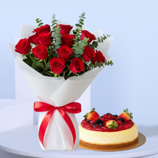 Flower Delivery Abu Dhabi 23 A bouquet of 13 red roses with eucalyptus leaves, wrapped in white, tied with a red ribbon, and a round cake topped with fresh strawberries, blueberries, and raspberries.