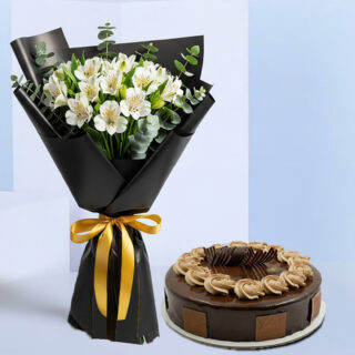 A bouquet of white alstroemeria flowers with eucalyptus, wrapped in black and tied with a gold satin ribbon, and a round chocolate cake.
