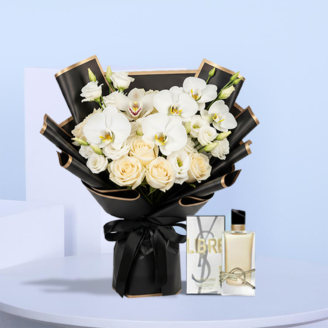 ysl-libre-white-orchids-cream-roses-bouquet-01 Black-wrapped bouquet of white phalaenopsis orchids, cream roses, and lisianthus with a satin ribbon, displayed beside a YSL Libre perfume box and bottle.