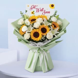 BTF Home 46 A bouquet with sunflowers, white roses, and lilies in mint green wrapping, tied with a satin ribbon and a cheerful " Get Well Soon" card.