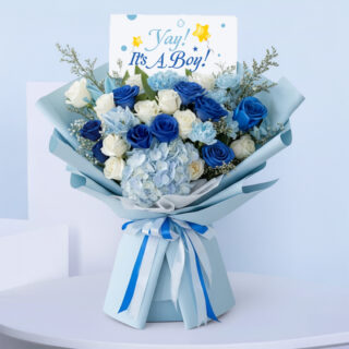 It’s a Boy blue bouquet with roses and hydrangeas - new baby flower arrangement wrapped in light blue paper.