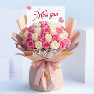 Miss You bouquet featuring pink and white roses hand-tied in blush wrapping with a satin ribbon and “Miss You” card.