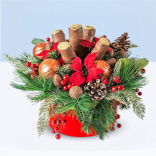 Festive chocolate and cake pop gift box decorated with greenery, red berries, pinecones, and edible chocolate ornament.