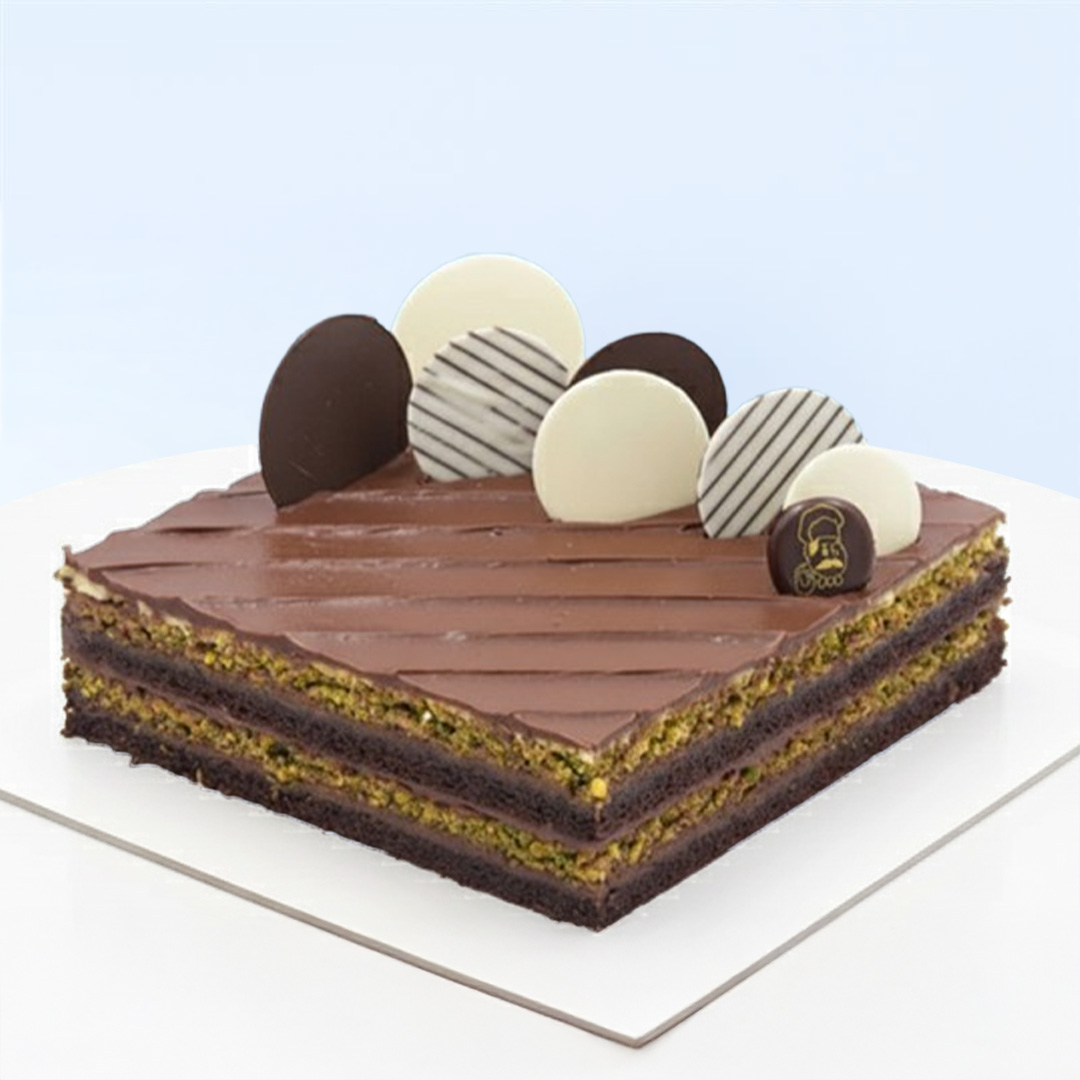 pistachio-nutella-cake Pistachio Nutella Cake 1 Kg by Mister Baker with pistachio sponge, buttercream, and Nutella filling topped with chocolate discs.