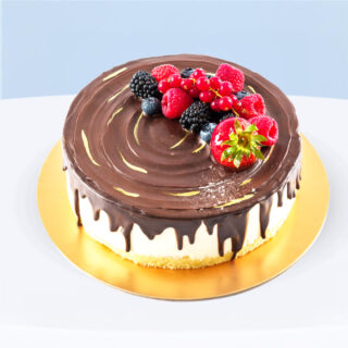 Chocolate glazed souffle birdy cake topped with chocolate glaze and fresh berries.