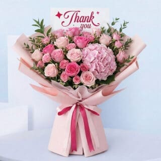 Thank You bouquet with pink roses, spray roses, and pink hydrangea in pink wrap.