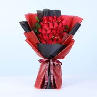 A bouquet of 25 red roses with ruscus greenery in red and black wrap.