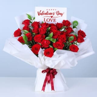 Bouquet of 25 red roses and lush greenery in white wrapping, finished with a message card.