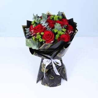 Hand-tied Valentine bouquet with fresh red roses wrapped in premium black paper and tied with a ribbon, designed for modern romantic gifting.