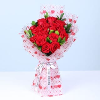 New Elegant Valentine bouquet of red roses and baby’s breath in heart-pattern wrapping.