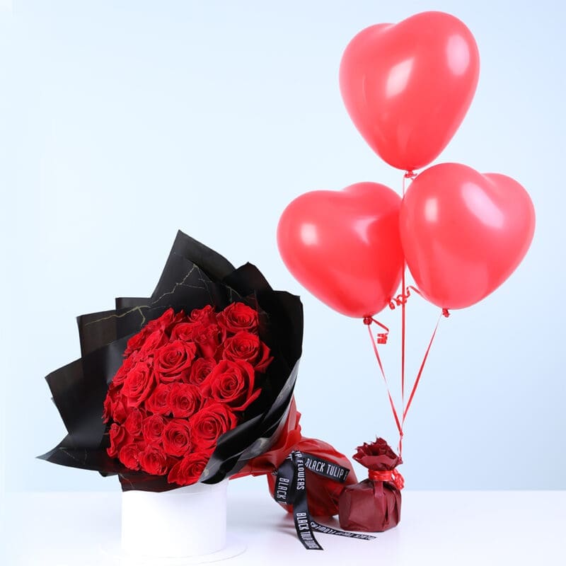 A bouquet featuring red roses in a premium black wrap, paired with three red heart balloons.