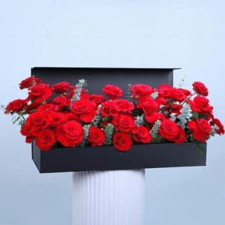 Red roses with eucalyptus arrangement in premium black box.