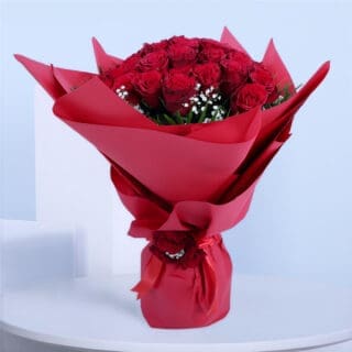 30 red roses with gypsophila and palm leaves in red wrap tied with a red ribbon.